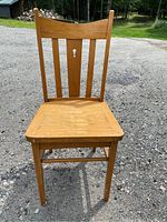 Front view of a wooden vintage chair showing the slatted back and seat