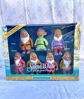 Full front view of original boxed seven dwarfs figurine set with visible characters and packaging text