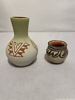 Both pottery pieces side by side on white background showing size and design differences.