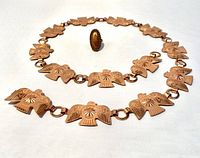 Photo of belt and ring displayed on white background, showing belt laid straight with ring centered inside belt circle