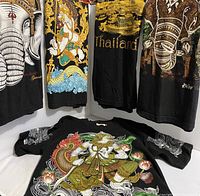 All five black cotton Thailand-themed T-shirts displayed with prints visible.