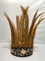 Front view of vintage feather headband showing tall rust-colored feathers and embroidered floral black band base.
