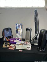Photo showing all items including Electrolux vacuum, Black & Decker floor sweeper, Turbo Scrubb scrubber, Swiffer Wet Jet refills, and two space heaters.