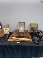 Overview of lot containing medieval decor, framed artwork, Book of Kells book, kitchen utensils, horse figurine, and vinyl records.