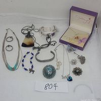 Full lot display showing all jewelry including necklace, bracelets, pins, pendants, and boxed item