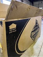 Closed cardboard box with Huffy logo and 'Do Not Lay Flat' label.