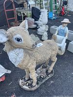 Full deer sculpture showing realistic textured fur, brown and white color, with a rocky base
