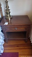 Full front view of nightstand with lamp on top