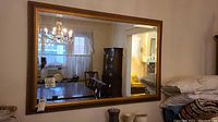 Full view of large rectangular beveled mirror reflecting room interiors.