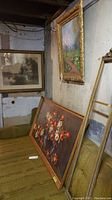 Three framed pieces of wall art and one blank frame leaning against a wall.