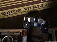 Close-up view of Kalart Editor Viewer Eight and Kodak Instamatic X-35 camera showing distinct design details and lenses