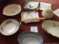 Full view of the lot showing various decorative bowls, plates and a candy dish on carpet, with a ruler for size reference