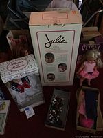 Full lot showing Julie doll box, Chrissy and Velvet dolls with clothing, and California Raisins figurine.