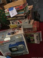 Photo showing a stack of various boxed board games and electronic games including Casino Craps and Chuck-A-Luck, a Whiz-Kid electronic computer game box, and others partly visible.