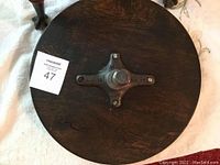 Top view of the round wooden seat showing the height adjustment screw mechanism.