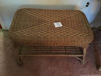 Front and top view of rectangular wicker coffee table showing woven wicker top surface and bottom slatted shelf.