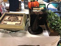 Photo showing decorative trays, faux ivy, and Halloween and holiday themed items on a table.