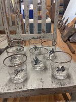 Set of 7 short clear glasses with ring necked pheasant images on a distressed white chair