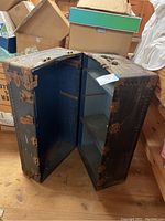 Open trunk showing blue fabric interior with built-in compartments/shelves on one side.