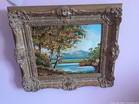 Full view of oil painting on board in ornate gilt wood frame against wall