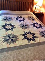 Wide view of queen-sized patchwork cotton duvet cover laid on bed showing multiple star-shaped patchwork blocks in blue, pink, grey, and off-white.