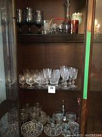 Glassware on shelves showing brandy snifters, wine glasses, pinwheel decorative bowls, and relish bowls