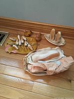 Photo showing brown ceramic chicken salt and pepper shakers, corn shaped condiment holders with mini corn cob shakers, and corn cob butter dish on wooden floor.