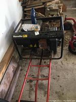 Three-quarter view of generator mounted on red hand cart with oil bottle and parts kit on fuel tank