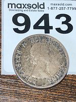 Photo of the obverse side of the 1960 Canadian silver dollar coin showing Queen Elizabeth II's portrait with worn details around the edges.