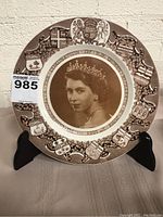 Front view of the Clarice Cliff commemorative plate on stand, showing full design and coat of arms border.