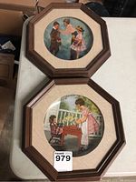 Photo showing two octagonal wooden frames containing collector plates with vintage children artwork.