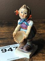 Full view of the Hummel Little Helper figurine standing on a square base, holding a basket