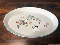 Full view of oval Royal Worcester quiche dish with botanical strawberry design and turquoise rim