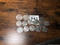 17 American and Canadian vintage coins laid out on a wooden table with a MaxSold lot number card.