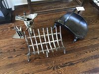 Overview of all fireplace tools including log holders, brushes, dustpan, and wine vessel showing wear and patina.