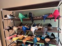 Three shelves of ladies shoes in assorted colors and styles, including heels and pumps, size approximately 7/37.