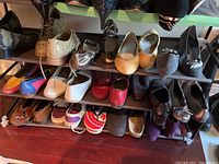 Three shelves filled with various women's shoes, mostly casual and dress styles, different materials and colors, size 7 approx.