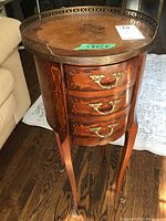 Front angle showing inlaid top, gallery rail and three drawers