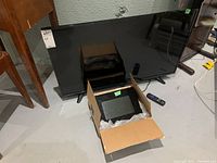 Full view of Sanyo Roku 40 inch LED TV with digital photo frame in box in front.