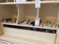 Shelf display of multiple fashion watches in metal and bracelet styles.