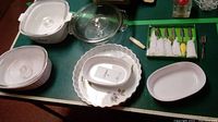 Evesham tart plate with floral pattern, three casserole dishes with lids (two white ceramic, one Blue Cornflower), two small oval plates, six knife spreaders with decorative handles wrapped in napkins, small silver plated fork
