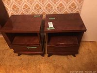 Pair of wooden nightstands shown from the front, displaying drawers and open shelves.