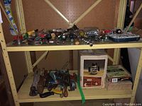 Shelves with various loose hand tools and boxed items below including hammers, saws, and screwdrivers.