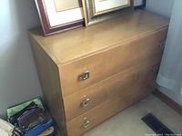 Full view of the vintage Mid-Century Modern dresser showing three drawers, wood finish, and square metal handles.
