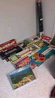 Overall view of puzzles, board games, and puzzle mat on floor.