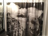 Black and white cityscape shower curtain with architectural details including clock tower and buildings under a cloudy sky.