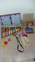 Wide view of puzzle boards, xylophone, boxes of toys, coins, and a hat on the floor