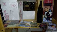 Wine labels and cardboard wine rack box alongside upright wine bottle.