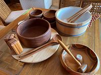 7-piece wood serving ware set including various bowls, wooden hammer, salt and pepper shakers, and a Lazy Susan displayed on a wood table.