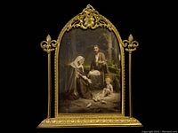 Front angled view of the antique gold-tone ornate gothic-style frame with holy family religious print, showing detailed floral and fleur-de-lis design elements on a black background.